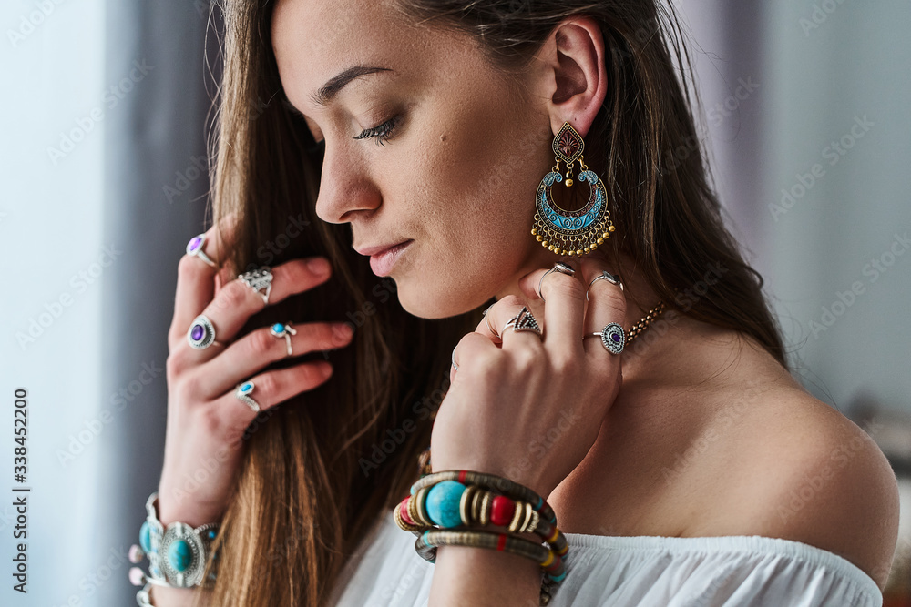 Stylish sensual boho chic woman in white blouse wears big earrings,  bracelets and silver rings. Fashionable indian hippie gypsy bohemian outfit  with imitation jewelry details Stock Photo | Adobe Stock