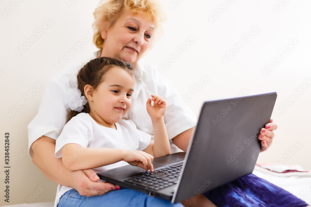 little girl and grandmother learning online on laptop little girl and grandmother learning online on laptop