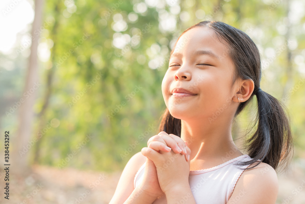 cute little girl hands praying to god with the bible in the morning on nature background. little asian girl hand praying for thank god. copy space. spirituality and religion faith hope concept. cute little girl hands praying to god with the bible in the morning on nature background. little asian girl hand praying for thank god. copy space. spirituality and religion faith hope concept.