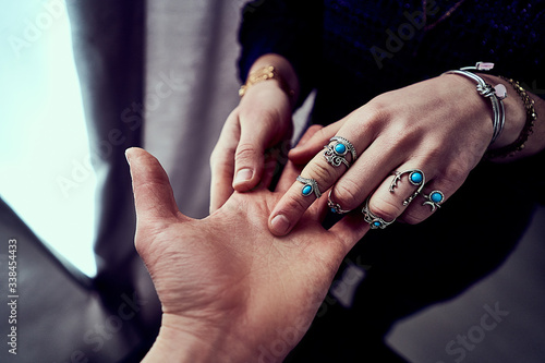 Fotografia Fortune teller woman wearing silver rings with turquoise stone and bracelets reads palm lines during fortune telling and prediction the future life