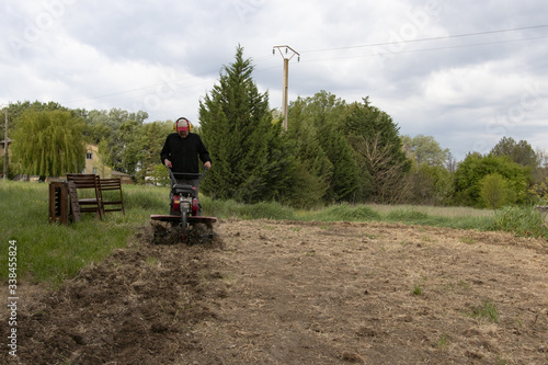 Un motoculteur retournant la terre