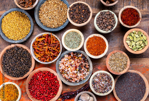 Fototapeta Naklejka Na Ścianę i Meble -  Indian spices collection, dried colorful condiment, nuts, pods and seeds and another spices in clay bowls