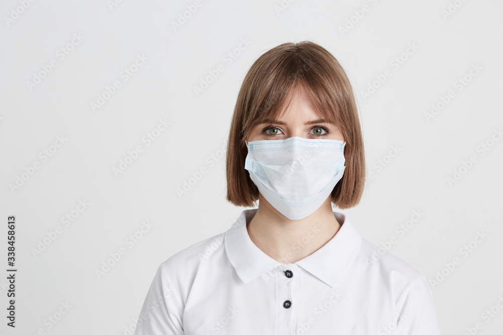 A young girl doctor in a surgical mask is preparing to receive patients with the virus. A young girl doctor in a surgical mask is preparing to receive patients with the virus.