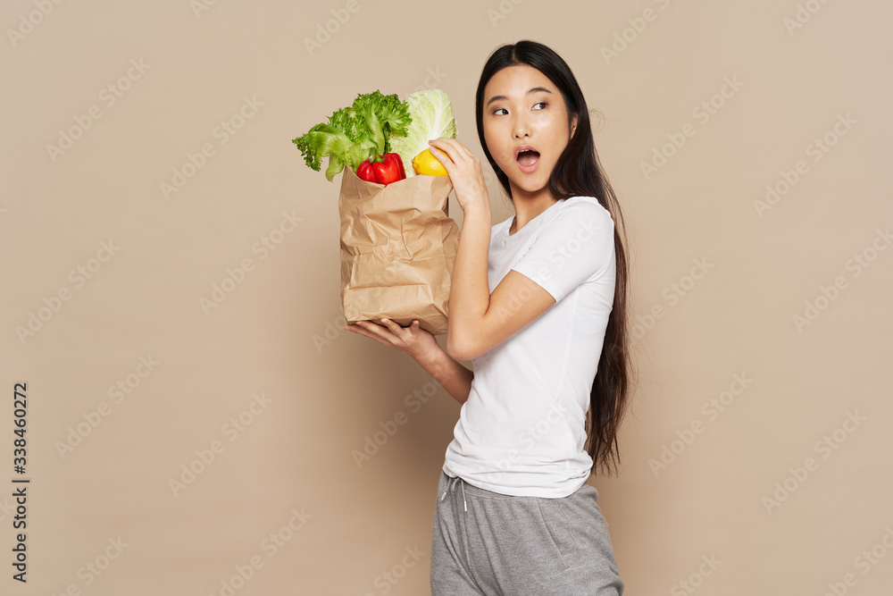 young woman holding a bag full of groceries young woman holding a bag full of groceries