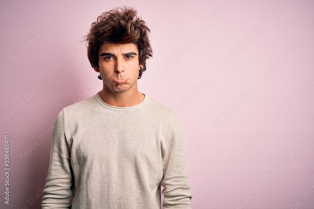 Young handsome man wearing casual t-shirt standing over isolated pink background depressed and worry for distress, crying angry and afraid. Sad expression. Young handsome man wearing casual t-shirt standing over isolated pink background depressed and worry for distress, crying angry and afraid. Sad expression.