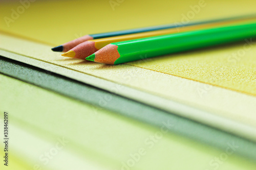 Green concept photo with pencils and paper in shades of green closeup