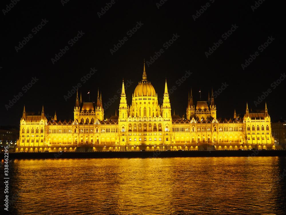 View of the Hungarian Parliament Building and the Danube river at night in Budapest, Hungary.