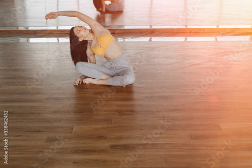 young attractive girl on a wooden floor doing yoga, stretching and relaxing © pressahotkey
