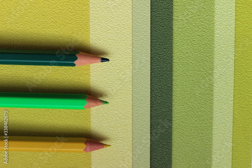 Green concept photo with pencils and paper in shades of green closeup