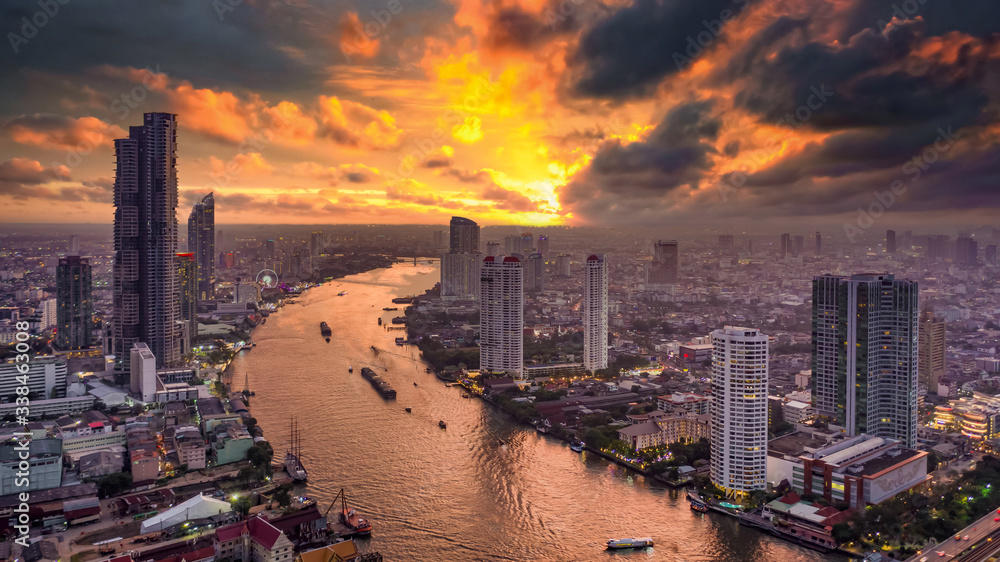 Aerial view Bangkok City skyline and skyscraper on Sathorn Road business and financial in Bangkok downtown, Taksin Bridge over Chao Phraya River, Bangkok, Thailand at sunset.