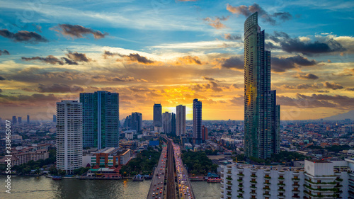 Aerial view Bangkok City skyline and skyscraper on Sathorn Road business and financial in Bangkok downtown, Taksin Bridge over Chao Phraya River, Bangkok, Thailand at sunset. photo