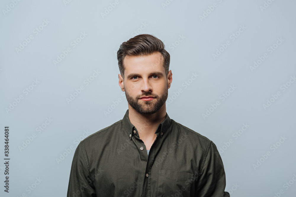 Handsome bearded man looking at camera isolated on grey Handsome bearded man looking at camera isolated on grey