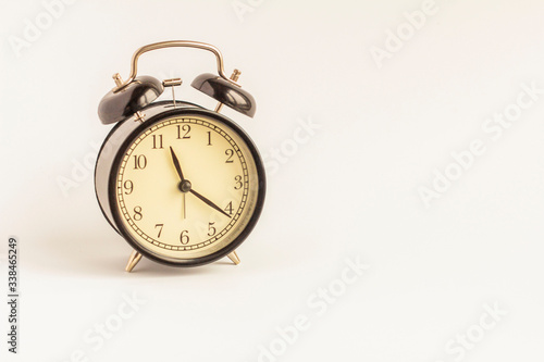 Analog black alarm clock on a white background.