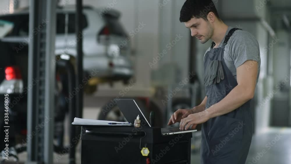 Car mechanic working on laptop in auto repair service. Car mechanic working on laptop in auto repair service.