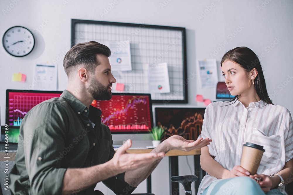 Data analyst planning work with colleague holding paper cup in office Data analyst planning work with colleague holding paper cup in office