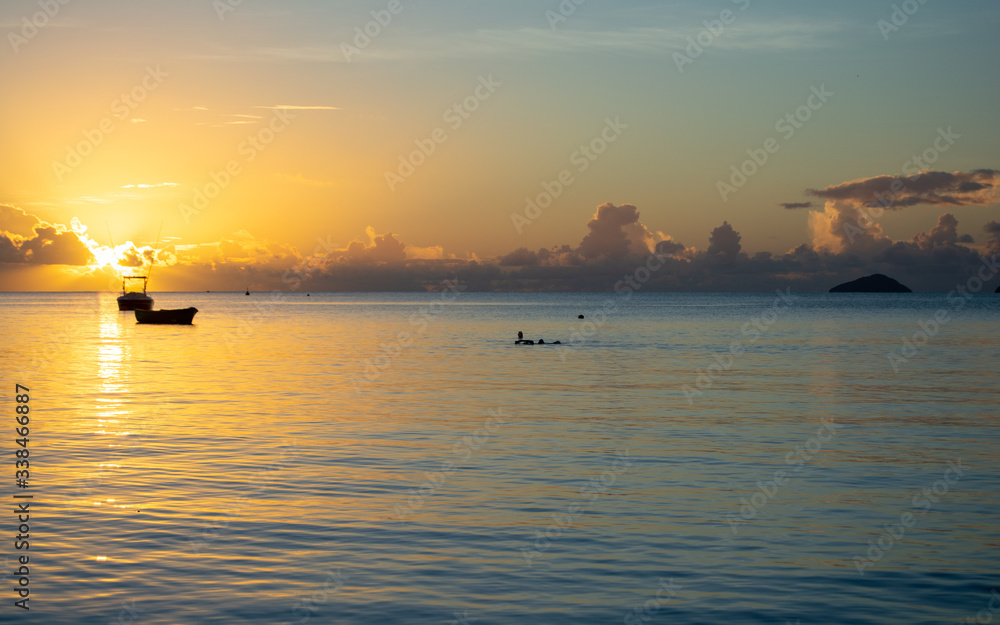 A tropical Sunset Landscape over the Indian Ocean.  The small boats in the Indian Ocean add to the depth and scale of the image.