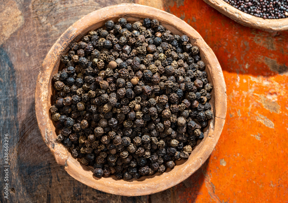 Indian spices collection, dried black peppercorns and another spices in clay bowls Indian spices collection, dried black peppercorns and another spices in clay bowls