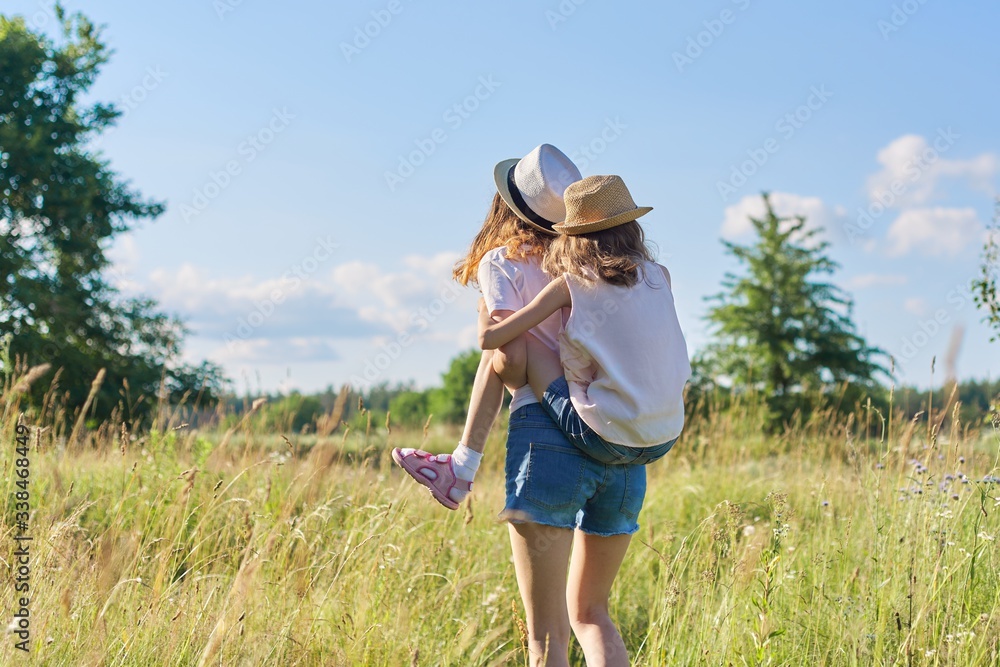 Happy children two girls sisters laughing and having fun in meadow Happy children two girls sisters laughing and having fun in meadow