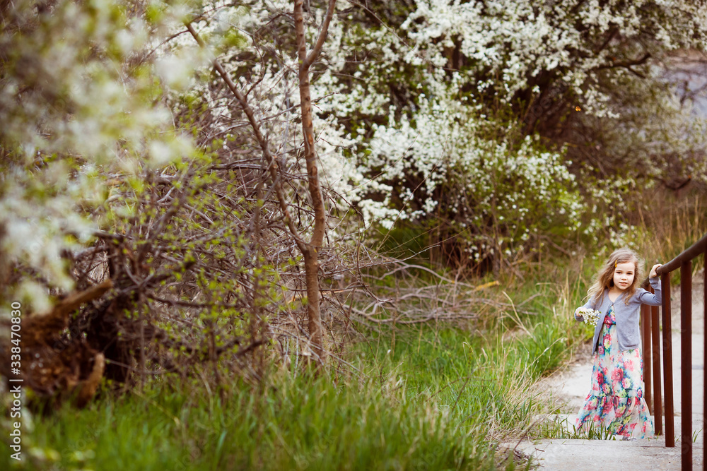 little girl climbs up stairs along flowering trees little girl climbs up stairs along flowering trees