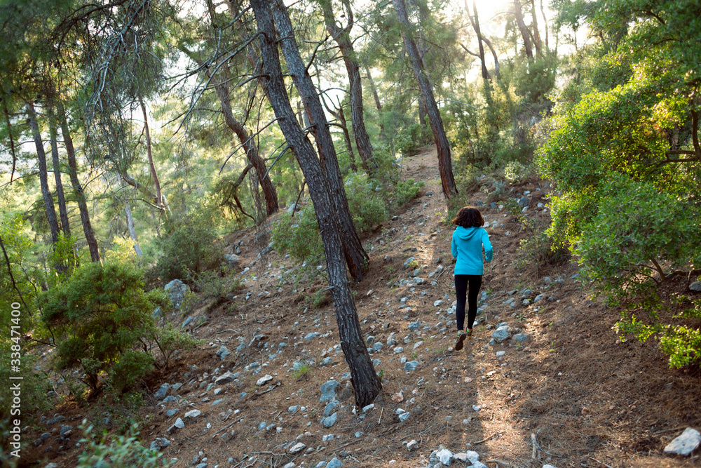 A woman runs along a mountain trail.