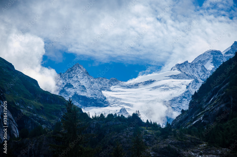 Mountain landscape, snowy mountain peaks.
Mountain, coniferous forests surrounded by mountains.
Summer alpine village. Alps mountain range.
Village in the mountains in the summer.