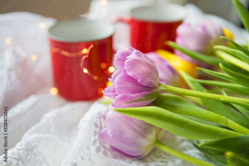 Beautiful morning, two cups of coffee and a bouquet of bright tulips.