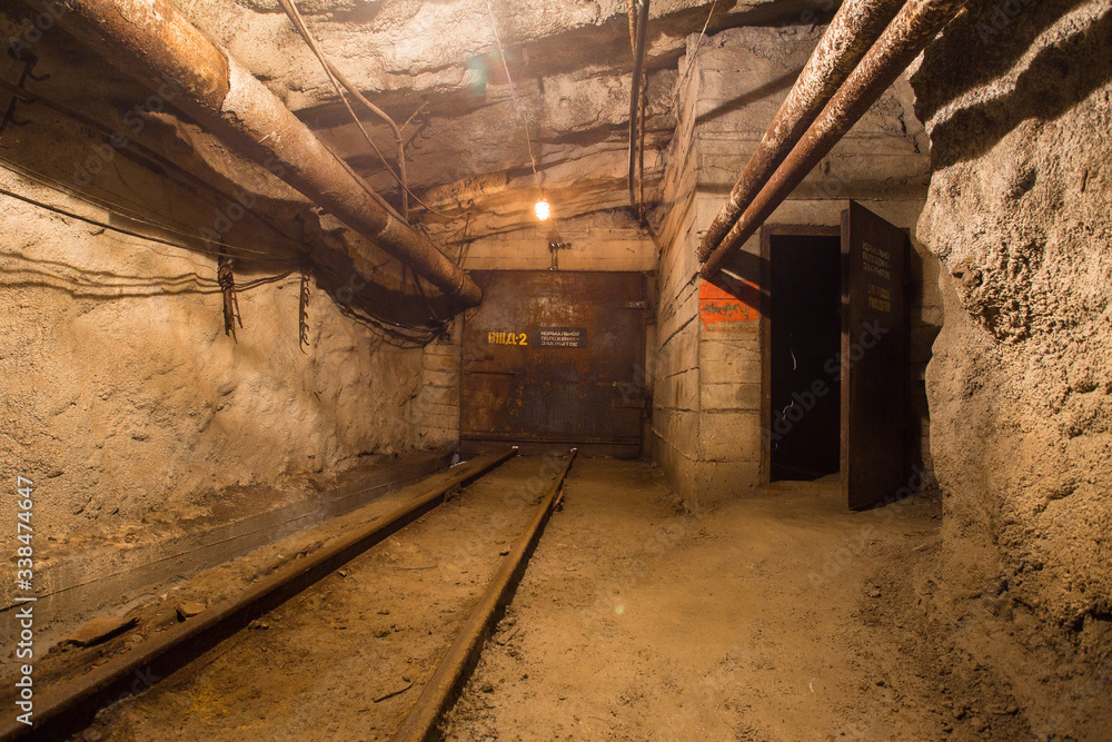 Naklejka premium Underground gold mine shaft tunnel drift with rails and doors
