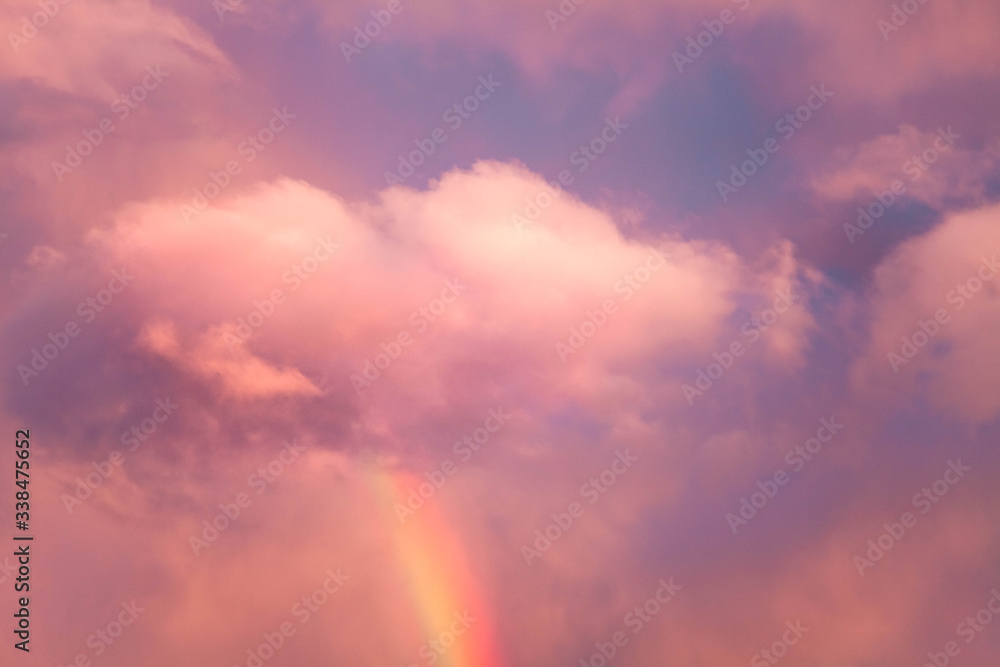 Sky background. Rainbow from pink fluffy colored cloud looks like cotton  candy or candy-floss at sunset. Beautiful purple and blue cloudy pattern.  Spring weather after rain. Stock Photo