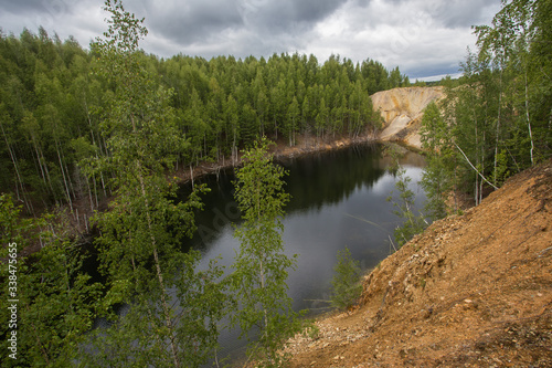 Flooded copper pyrite open pit quarry with brown water lake