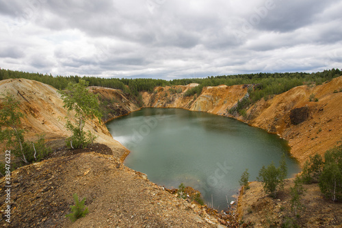 Flooded copper pyrite open pit quarry with green water lake