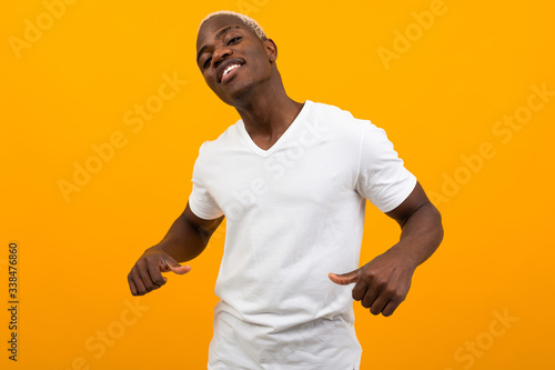 cute charming handsome black american man in white t-shirt with mockup on yellow background
