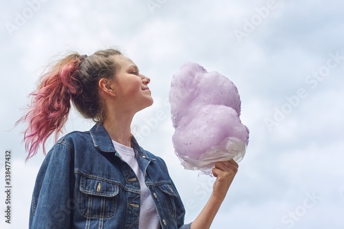 Obraz na plátně Beautiful smiling teenage girl with pink hair, hairstyle holding candy floss