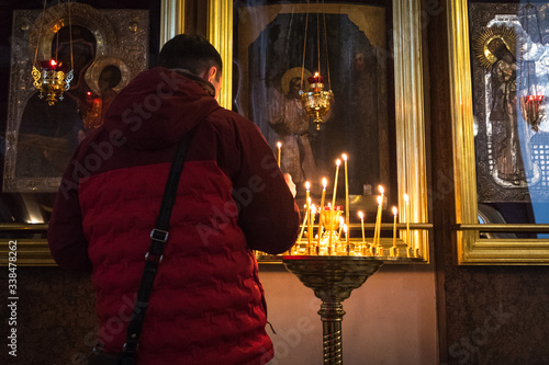 Saint Petersburg, Russia: a believer lights a candle in front of icons in Kazan Cathedral. The cathedral is one of the main centers of the religious life of the city. photo