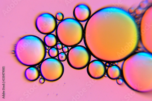 Pink oil bubbles in a liquid. Beautiful structure of oil and water in macro as abstract background.