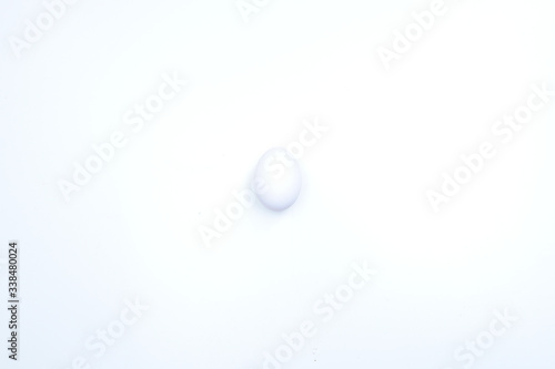White chicken egg on a white background with shadows