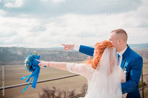 bride and groom point to the distance photo