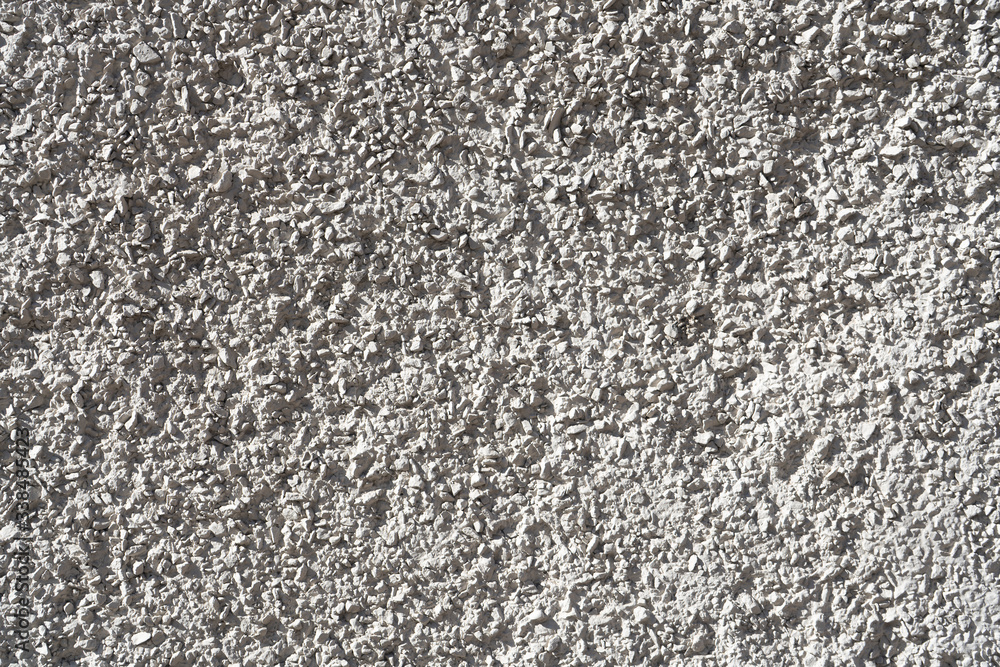 The facade of the building is made of white marble chips. Texture for the background. The facade of the building is made of white marble chips. Texture for the background.