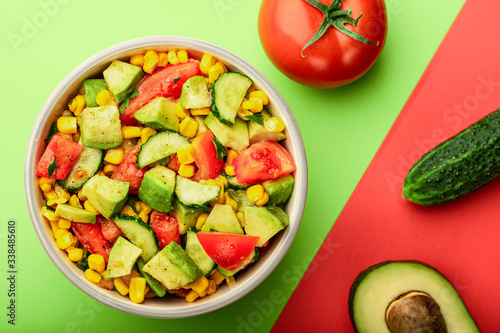 Top view bowl of avocado and tomato salad with cucumber