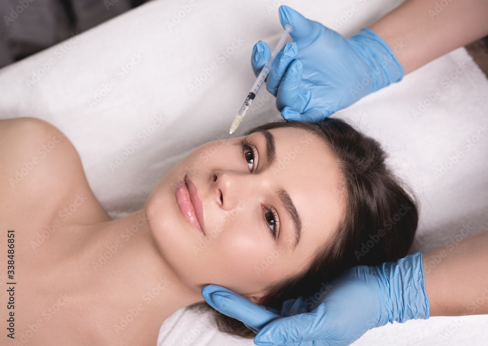 Beauty Injection. Closeup Of Doctor Hands With Syringe Near Female Face. Portrait Of Beautiful Woman Receiving Facial Skin Lifting Treatment. Beauty Injection. Closeup Of Doctor Hands With Syringe Near Female Face. Portrait Of Beautiful Woman Receiving Facial Skin Lifting Treatment.