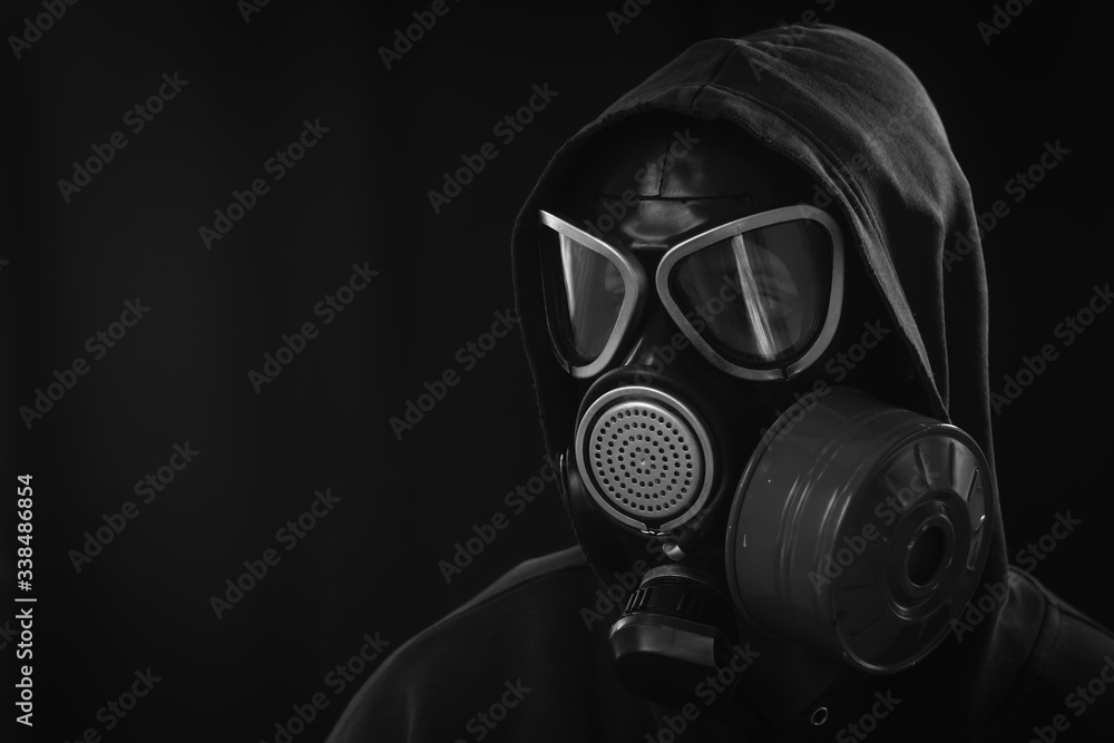 The girl is wearing a military gas mask. Isolated on a black background. Respiratory protection against harmful toxic substances, aerosols and viruses. Copy space, place for text. Black and white The girl is wearing a military gas mask. Isolated on a black background. Respiratory protection against harmful toxic substances, aerosols and viruses. Copy space, place for text. Black and white