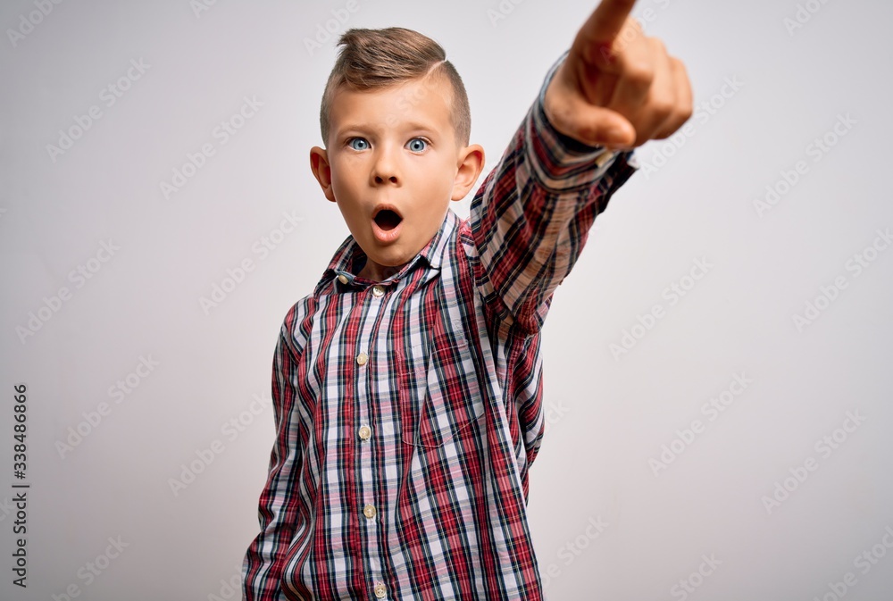 Young little caucasian kid with blue eyes wearing elegant shirt standing over isolated background Pointing with finger surprised ahead, open mouth amazed expression, something on the front Young little caucasian kid with blue eyes wearing elegant shirt standing over isolated background Pointing with finger surprised ahead, open mouth amazed expression, something on the front