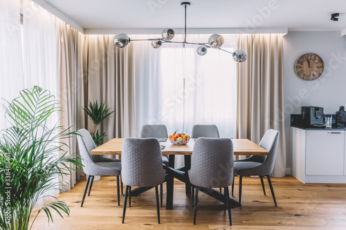 Schilderij op canvas Dining room with wooden table and floor in modern apartment.