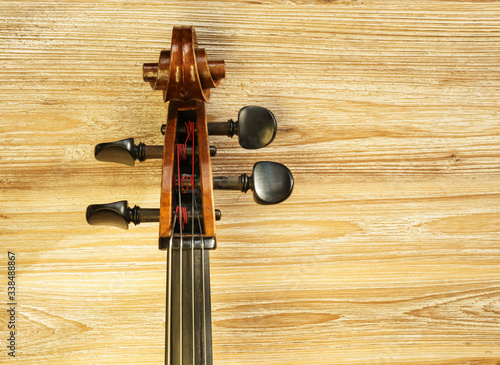 Tableau sur toile Neck and headstock of a cello on the left side of the image on a textured wooden background