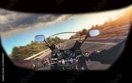 motorbike travel along the road with a view of the driver in a helmet
