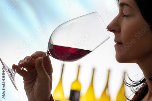 Female wine steward smelling red wine aroma.