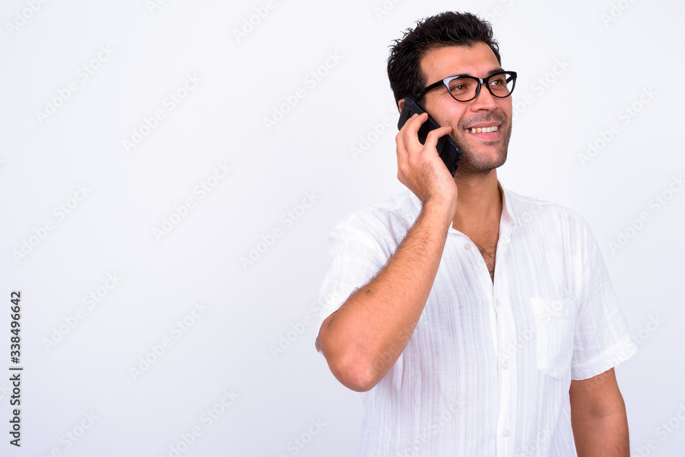 Portrait of happy handsome Turkish man thinking while talking on the phone Portrait of happy handsome Turkish man thinking while talking on the phone