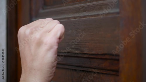 Man Hand Knocking on a Wooden Door, Close Up
