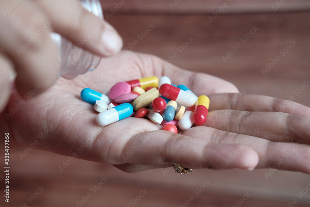 close up of white pills on palm of women hand close up of white pills on palm of women hand