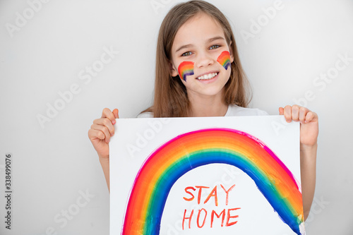 teen girl drew rainbow and poster stay home.  photo