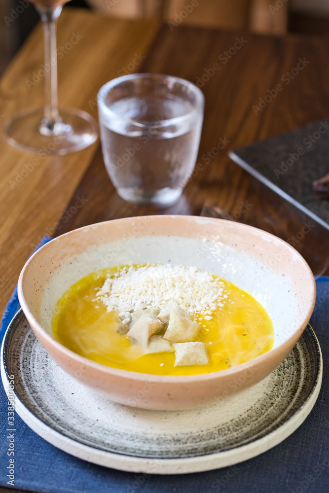 Yellow cream soup with croutons on a served table Yellow cream soup with croutons on a served table